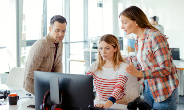 Three people looking at a computer screen