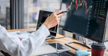 woman pointing at stocks on a computer