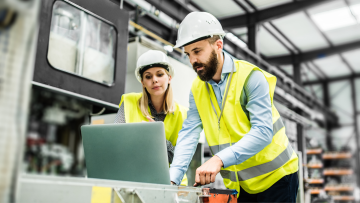 two people in a warehouse looking at a computer