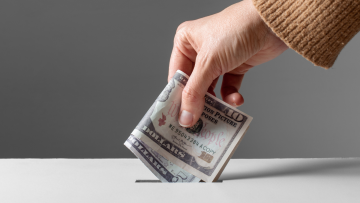 putting cash in a donation box