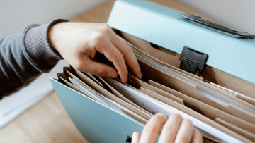 sorting through files in a blue file folder