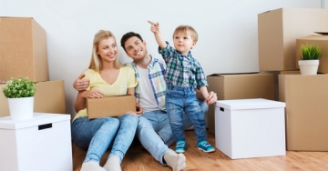 child with parents and moving boxes