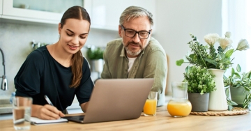 dad and daughter looking at laptop