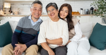 family smiling while sitting on a couch