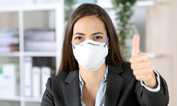 woman with mask thumbs up