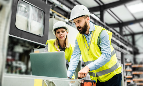 two people in a warehouse looking at a computer