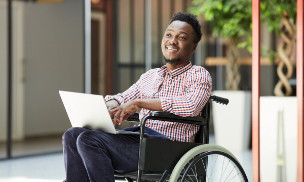 man in a wheelchair using a laptop