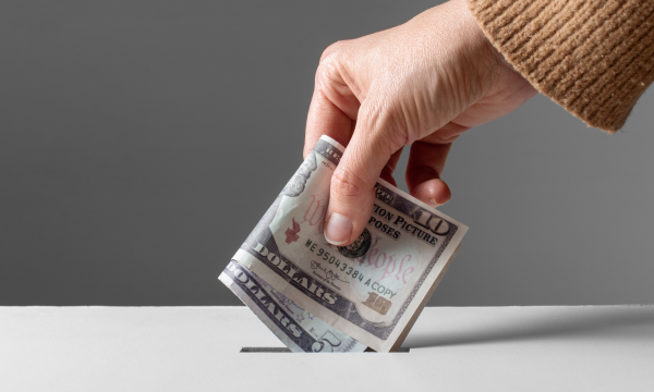 putting cash in a donation box