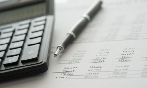 calculator next to a pen and paper