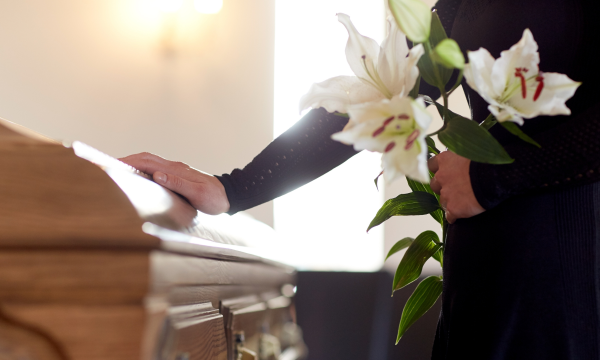 mourner holding lilies at a casket