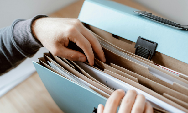 sorting through files in a blue file folder