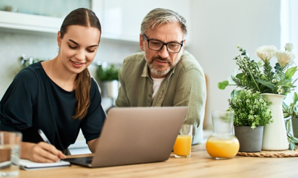 dad and daughter looking at laptop
