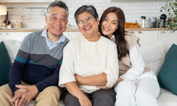 family smiling while sitting on a couch