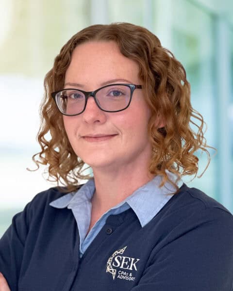 Professional woman CPA advisor with glasses in office setting.