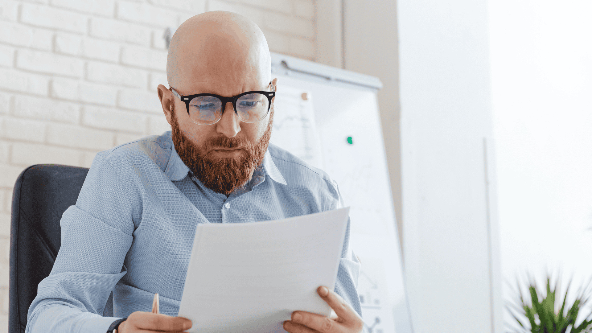 man in a blue shirt holding papers