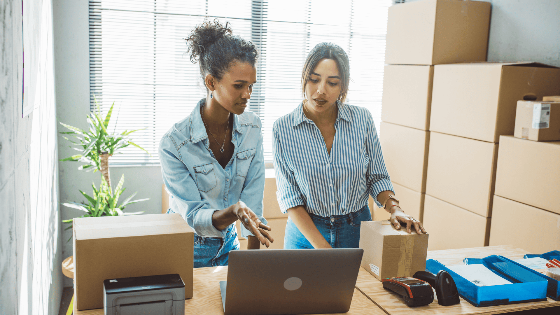 Two women working at a desk while shipping orders