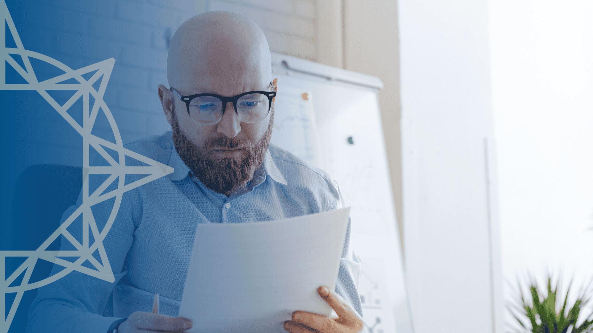 Man in blue shirt looking at paperwork