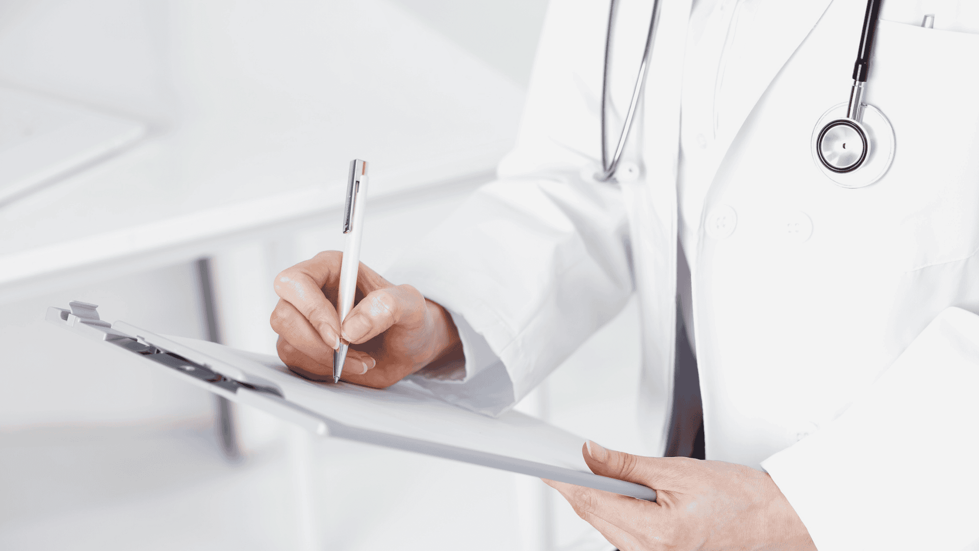 Physician filling out paperwork on a clipboard