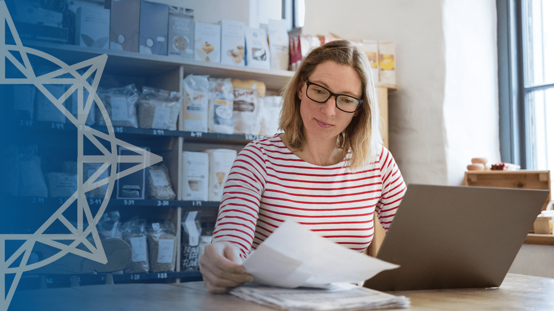 woman in red and white striped top reviewing papers at desk in a store