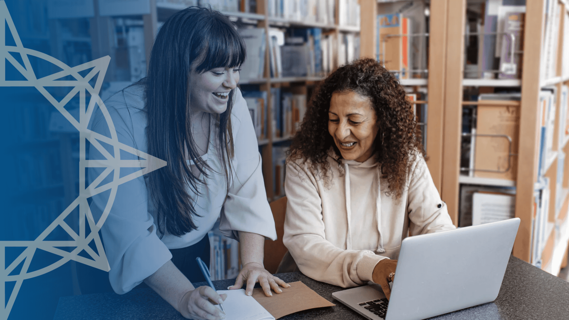 Two women in a library looking at a laptop